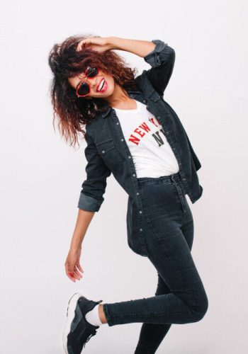 amazing-slim-female-model-black-pants-standing-one-leg-isolated-with-smile-curly-brunette-girl-dancing-trendy-sneakers-smiling